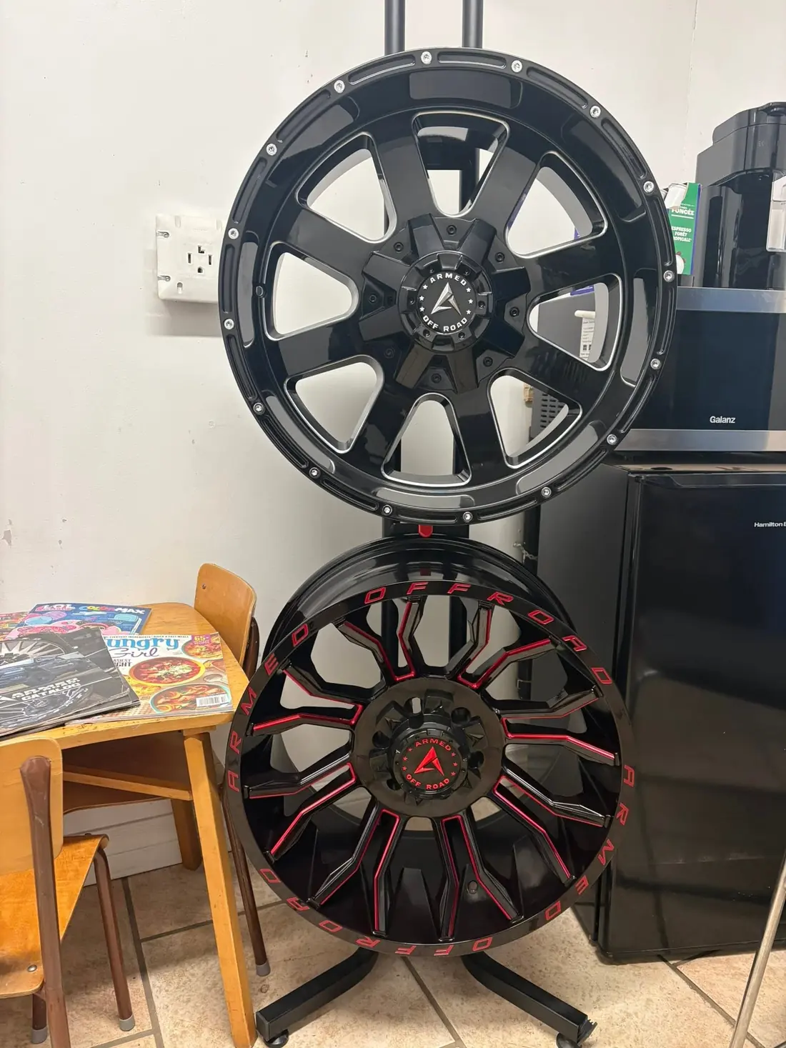 Aftermarket truck wheels on a display stand in the AutoNorth customer waiting area