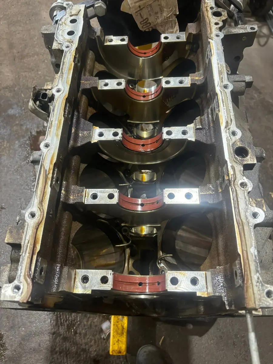 Engine block on a bench with the crankshaft laid in and the main bearing caps and shells in place, at AutoNorth Auto Repair in North Bay