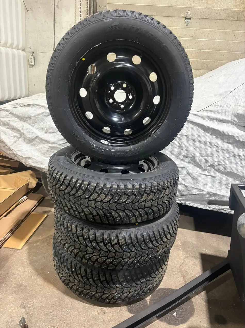 Set of four winter tires mounted on black steel rims at AutoNorth in North Bay